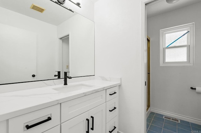 full bath featuring vanity, tile patterned floors, baseboards, and visible vents