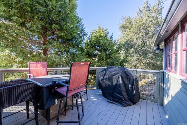 wooden deck with a grill and outdoor dining space