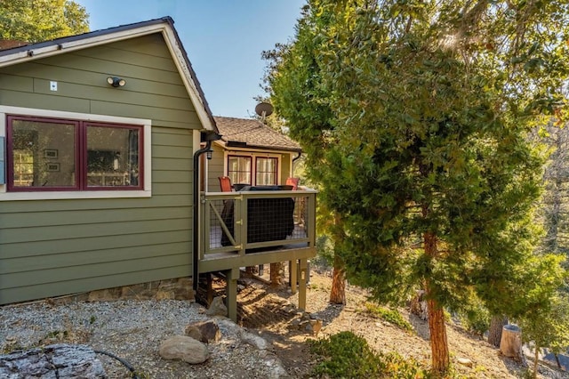 view of home's exterior featuring a deck and a shingled roof