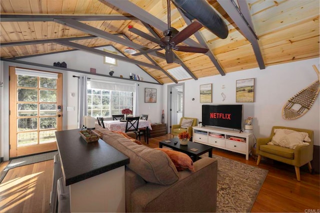 living area featuring wood finished floors, vaulted ceiling with beams, wood ceiling, and ceiling fan