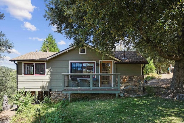 back of property featuring a yard and a wooden deck