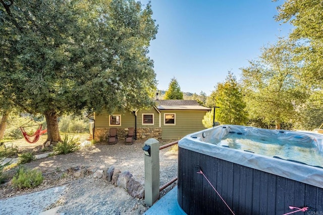 view of front of home featuring stone siding and a hot tub