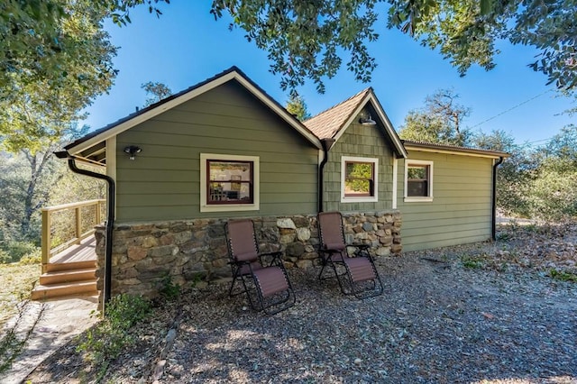 rear view of house with stone siding