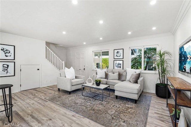 living room with ornamental molding, recessed lighting, light wood-style floors, baseboards, and stairs