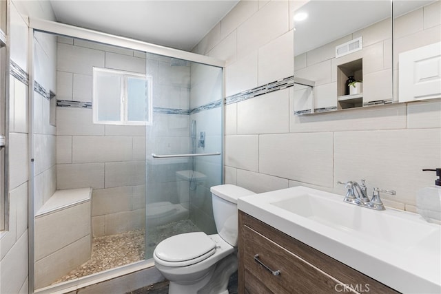 bathroom with toilet, tile walls, a shower stall, decorative backsplash, and vanity