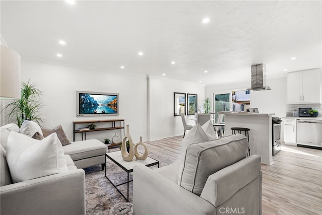 living room with recessed lighting, light wood-type flooring, and ornamental molding