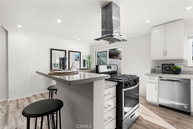 kitchen with tasteful backsplash, crown molding, a kitchen breakfast bar, island exhaust hood, and stainless steel appliances