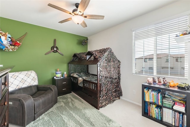 carpeted bedroom featuring baseboards and a ceiling fan