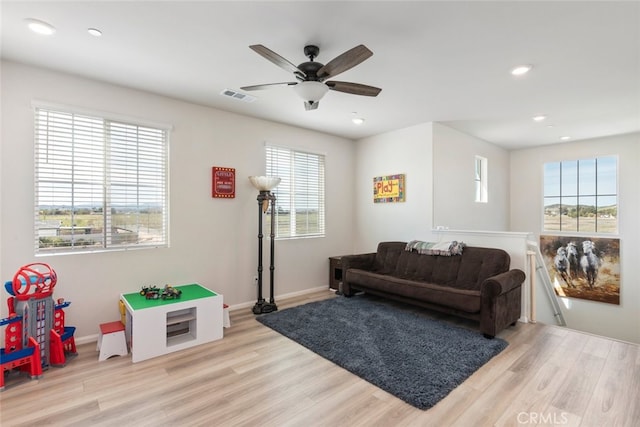 living area with light wood-style flooring, recessed lighting, visible vents, and a wealth of natural light