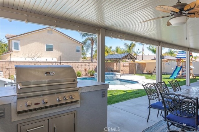 view of patio featuring a fenced backyard, a playground, a grill, outdoor dining area, and an outdoor kitchen