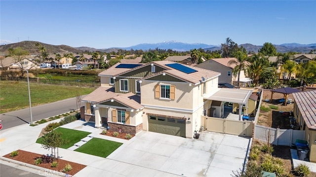 view of front of property with solar panels, a mountain view, fence, and a gate