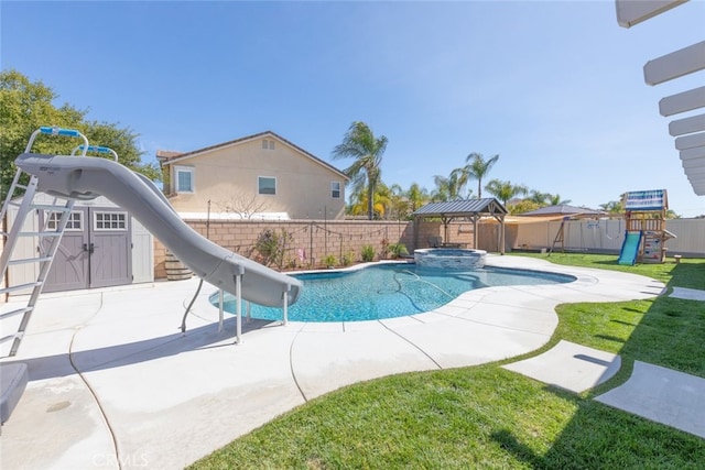 view of pool with a patio, a water slide, a fenced backyard, and a playground