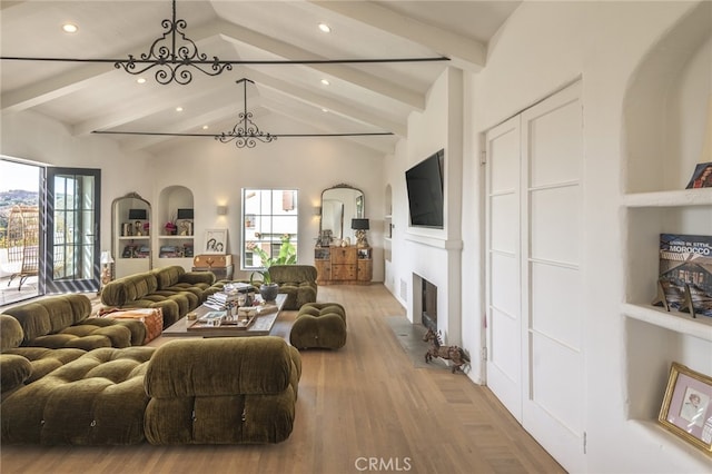 living room featuring wood finished floors, an inviting chandelier, vaulted ceiling with beams, recessed lighting, and a fireplace with flush hearth