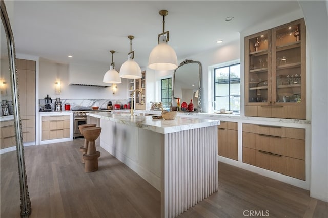 kitchen featuring custom exhaust hood, light wood-style flooring, an island with sink, high end stainless steel range, and modern cabinets