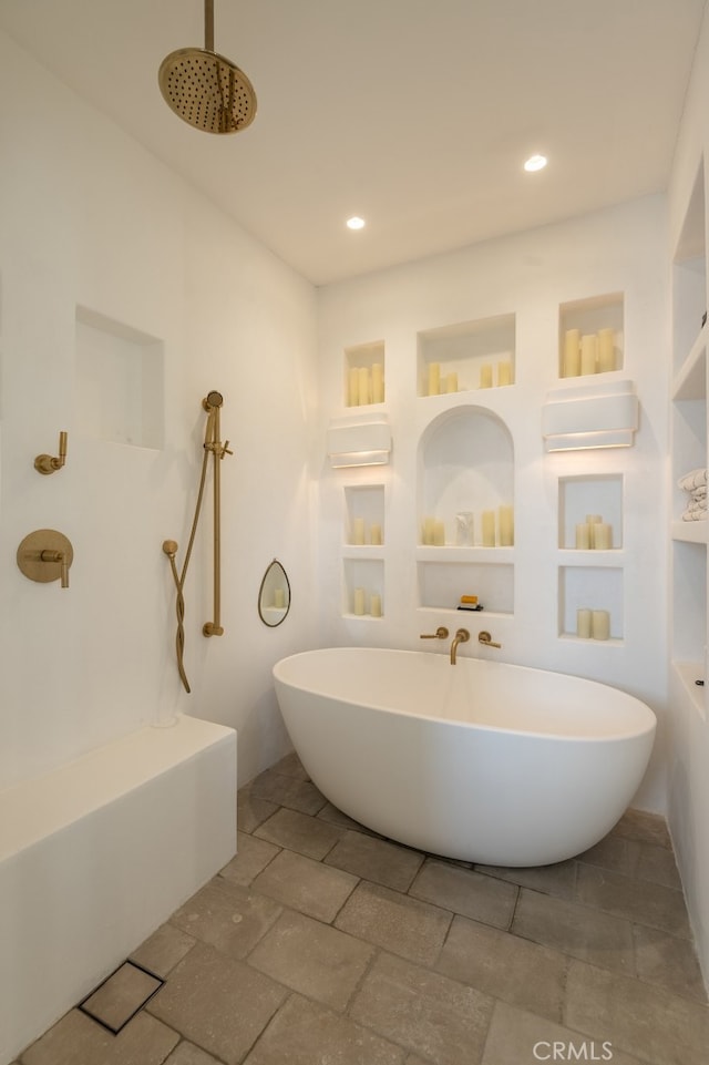 full bath with recessed lighting, built in shelves, a shower, and a freestanding tub