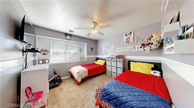 carpeted bedroom with ceiling fan, visible vents, and a textured ceiling