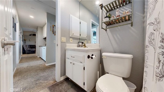 bathroom with baseboards, toilet, and vanity