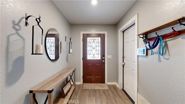 foyer entrance with baseboards and light wood finished floors