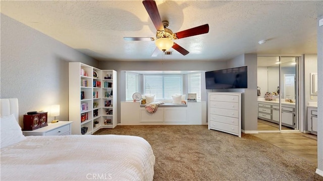 carpeted bedroom featuring a ceiling fan and a textured ceiling