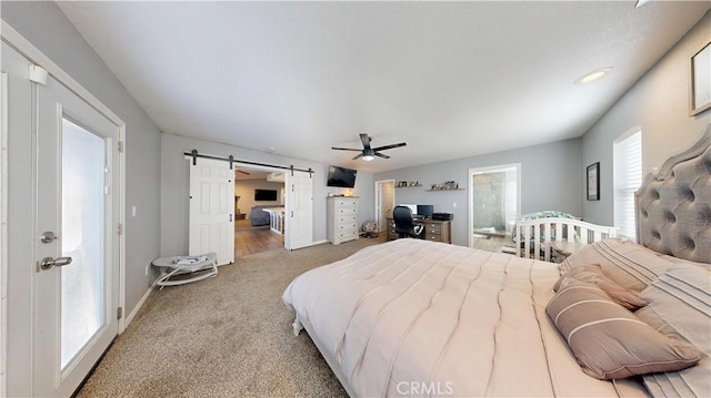 bedroom with a barn door, a ceiling fan, baseboards, and light carpet