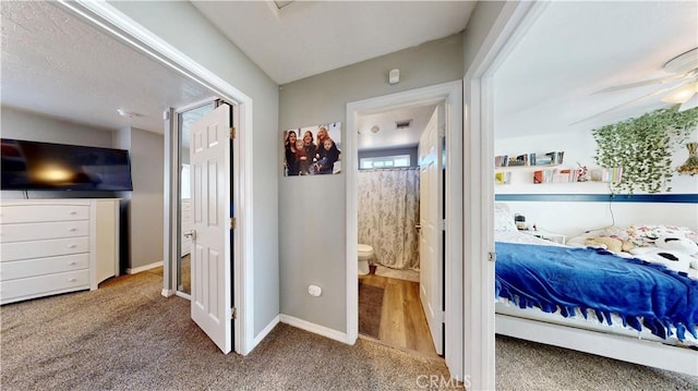 bedroom with baseboards, ensuite bathroom, and carpet flooring