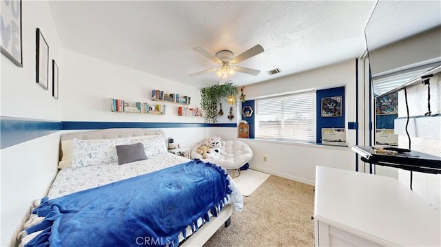 bedroom with visible vents, baseboards, ceiling fan, carpet flooring, and a textured ceiling