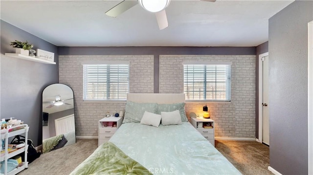 carpeted bedroom with multiple windows, brick wall, baseboards, and a ceiling fan