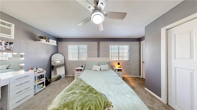 carpeted bedroom with brick wall and a ceiling fan