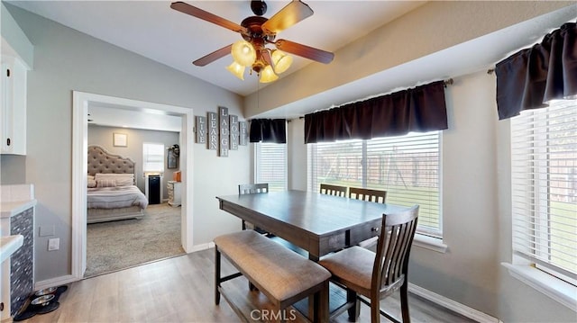 dining area with vaulted ceiling, plenty of natural light, baseboards, and light wood finished floors