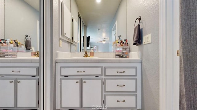 full bath featuring vanity and a textured wall