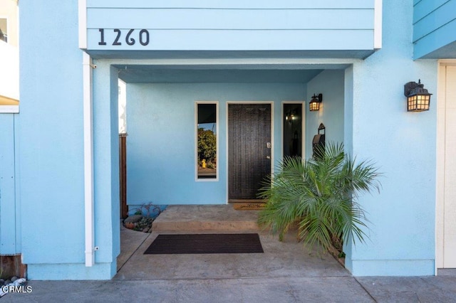 entrance to property featuring stucco siding