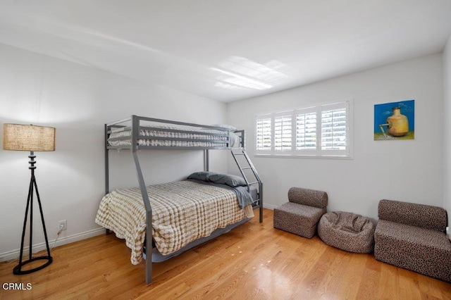 bedroom with baseboards and wood finished floors