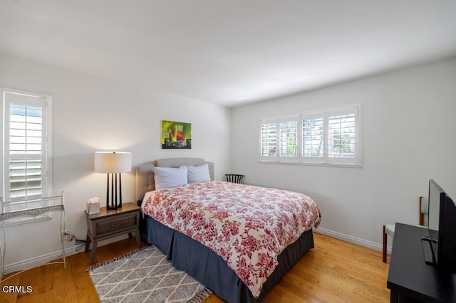 bedroom with light wood-style flooring and baseboards