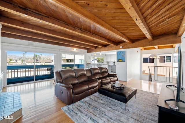 living room featuring beam ceiling, plenty of natural light, and wooden ceiling