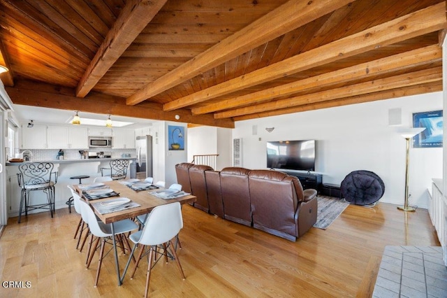 dining space featuring beam ceiling, visible vents, light wood-style flooring, and wooden ceiling