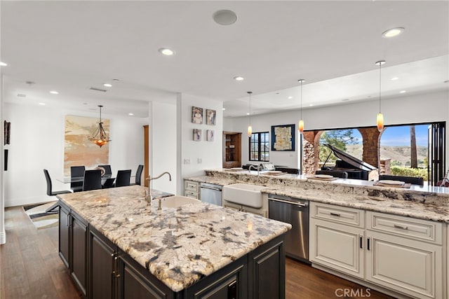 kitchen featuring a sink, light stone counters, recessed lighting, stainless steel dishwasher, and dark wood-style flooring