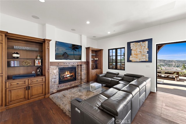 living area with recessed lighting, dark wood-style flooring, and a fireplace