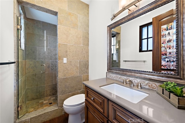 full bath featuring a stall shower, toilet, and vanity