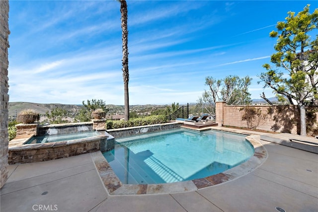 view of pool featuring a pool with connected hot tub and fence