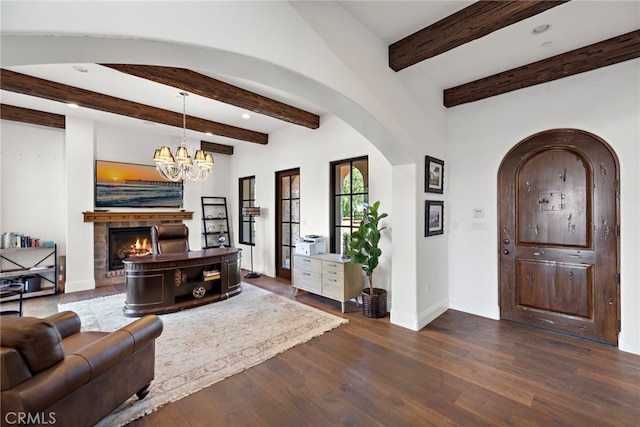 living room featuring dark wood finished floors, a warm lit fireplace, arched walkways, and baseboards