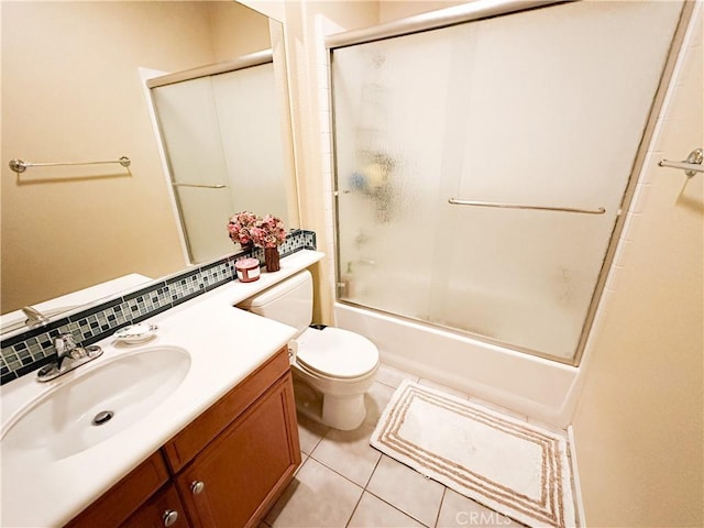 full bathroom featuring vanity, bath / shower combo with glass door, tile patterned floors, toilet, and tasteful backsplash