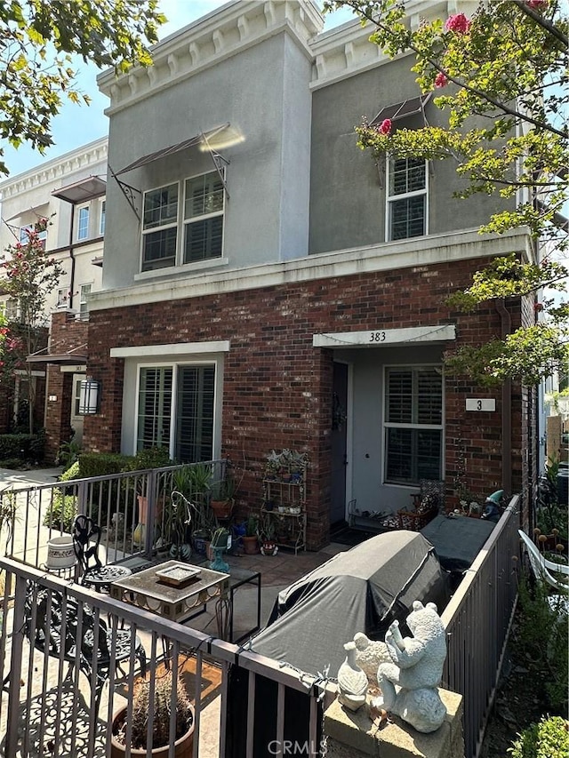 view of front of house with stucco siding and brick siding