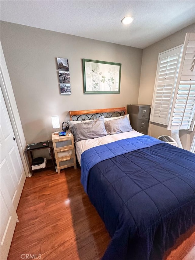 bedroom featuring a textured ceiling and wood finished floors