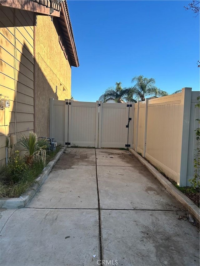 view of patio featuring fence and a gate