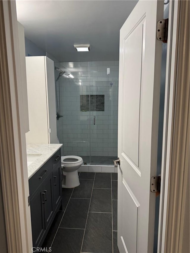 full bathroom with tile patterned floors, toilet, a stall shower, and vanity