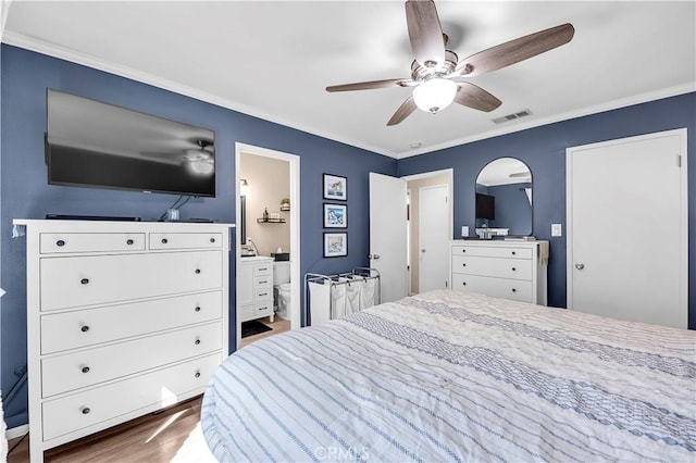 bedroom with a ceiling fan, wood finished floors, visible vents, and ornamental molding