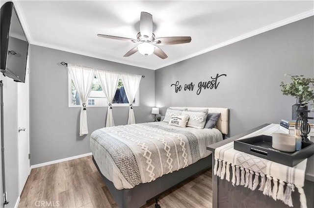 bedroom with ceiling fan, wood finished floors, baseboards, and ornamental molding