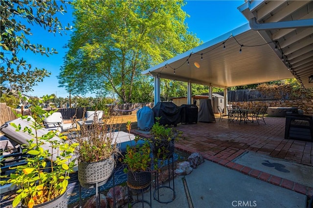 view of patio featuring a grill, a fenced backyard, and outdoor dining space