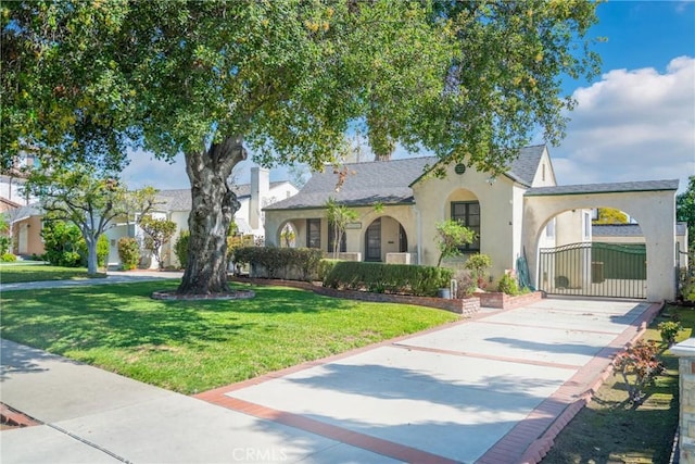 view of front of home featuring a shingled roof, a front lawn, stucco siding, driveway, and a gate