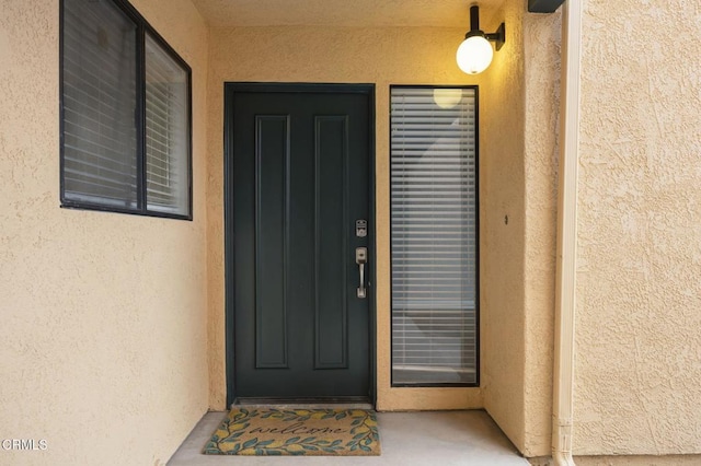 entrance to property featuring stucco siding